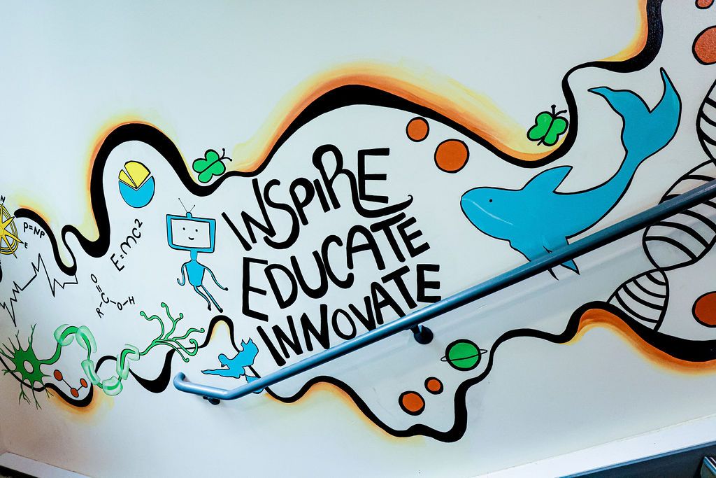 The painted upper wall: Inspire, Educate, Innovate with the blue dolphin