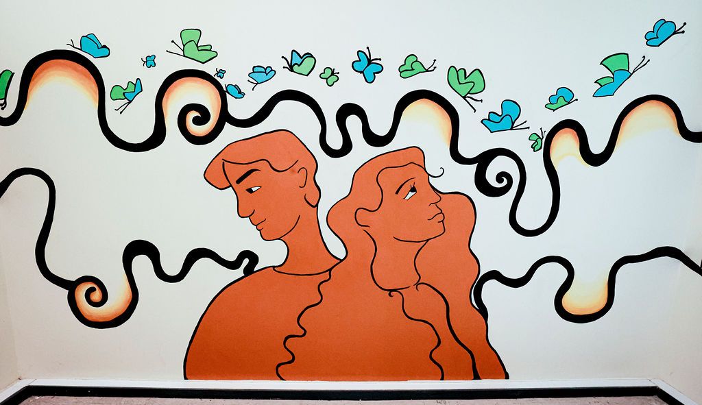 The painted middle wall: the two figures in terracotta beneath green and blue birds