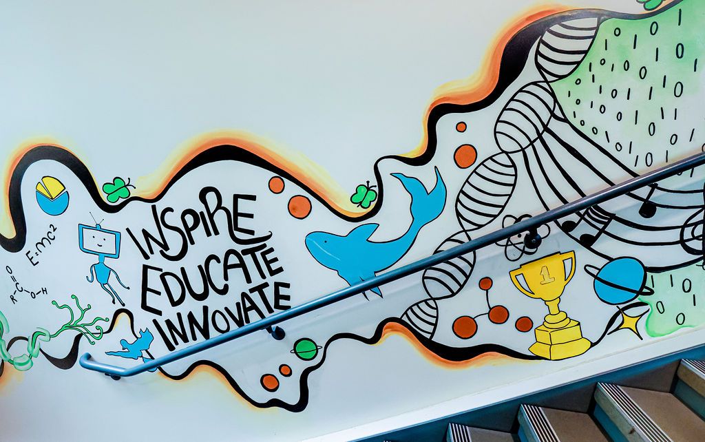 Upper wall: Inspire, Educate, Innovate with a blue dolphin and a DNA helix